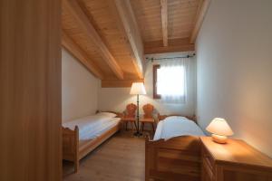 a bedroom with two beds and a window at Trais Fluors C3 in Maloja