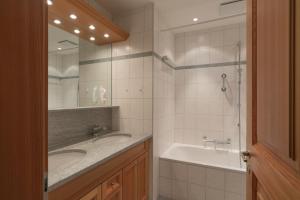 a bathroom with two sinks and a large mirror at Trais Fluors C3 in Maloja +26 photos