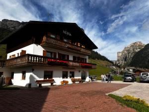 a building with benches in front of it at Garni Neidia in Selva di Val Gardena