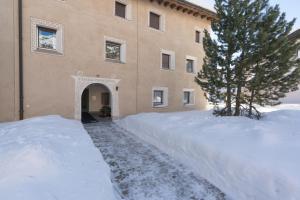 a building with a pile of snow in front of it at Chesa Cravunera 29 in Sils Maria +3 photos