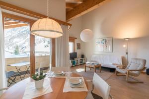 a living room with a table and a dining room at Chesa Cravunera 29 in Sils Maria
