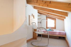 a room with a bed and a chair in a room at Chesa Cravunera 29 in Sils Maria