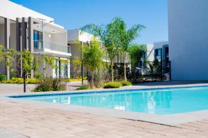 a swimming pool in front of a building at The Captains Suite in Gaborone