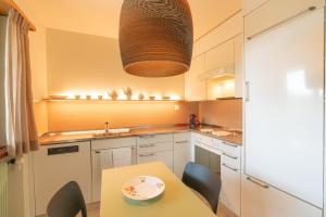 a kitchen with white cabinets and a table with chairs at Chesa Tscheppa 1 in Sils Baselgia