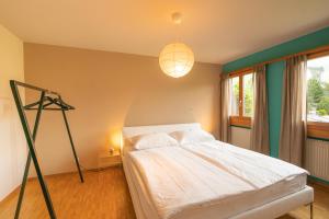 a bedroom with a white bed and a tripod at Chesa Tscheppa 1 in Sils Baselgia