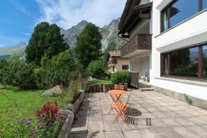 a patio with a table and chairs in front of a house at Chesa Tscheppa 1 in Sils Baselgia +18 photos
