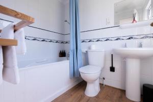 a white bathroom with a toilet and a sink at Hot Tub With A View - Christchurch Harbour in Christchurch +41 photos