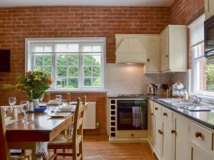 a kitchen with a table and a brick wall at The Stables in Eardisland