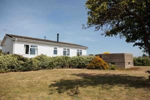 a white house with a yard in front of it at Hot Tub With A View - Christchurch Harbour in Christchurch