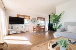 a living room with a couch and a table at Hot Tub With A View - Christchurch Harbour in Christchurch