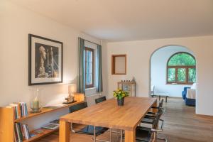 a living room with a wooden table and a room at Chesa Clos in Sils Baselgia