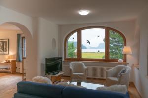 a living room with a blue couch and a window at Chesa Clos in Sils Baselgia