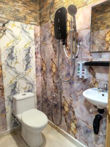 a bathroom with a toilet and a sink at Tang Hotel in Alor Setar
