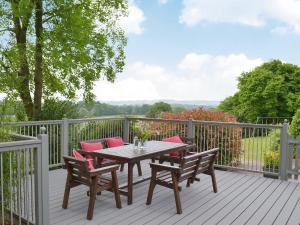 a wooden deck with a table and chairs on it at The Goyle-E4528 in Uplowman