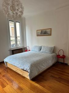 a bedroom with a bed and a window and a chandelier at L'Angolo di Mede in Mede