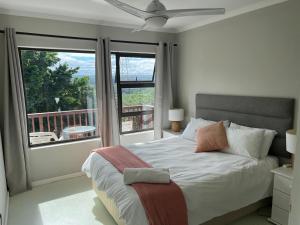 a bedroom with a large bed and a balcony at Fever Tree B&B in Gonubie Manor