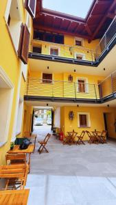 a building with wooden tables and benches in a courtyard at Residence Besano in Besano