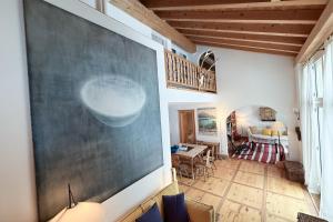 a living room with a large painting on the wall at Residenza Alpenrose 61 in Sils Maria