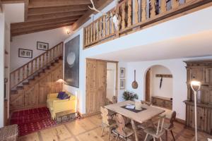 a living room with a table and a yellow chair at Residenza Alpenrose 61 in Sils Maria