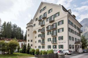 a large white building with cars parked in front of it at Residenza Alpenrose 61 in Sils Maria