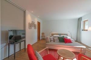 a living room with a couch and a tv at Chesa Piol Studio in Maloja