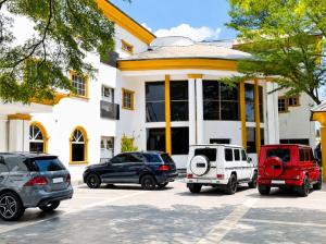 a group of cars parked in front of a building at de brit hotel in Benin City