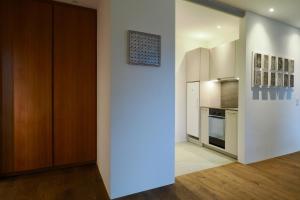 a kitchen with white walls and a wooden door at Chesa Piol Studio in Maloja