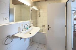 a bathroom with a sink and a shower at Residenza Alpenrose 61 in Sils Maria +21 photos