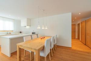 a kitchen and dining room with a wooden table and chairs at Chesa Blaunca B4 in Maloja