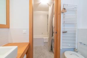 a bathroom with a sink and a toilet and a tub at Chesa Blaunca B4 in Maloja +8 photos