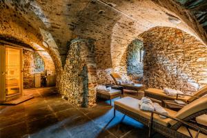 a room with a stone wall with couches and chairs at Schloss Purschenstein in Neuhausen
