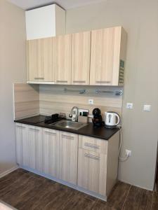 a kitchen with wooden cabinets and a sink at Green apartments in Primorsko
