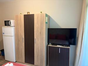 a large wooden cabinet with a flat screen tv at Green apartments in Primorsko