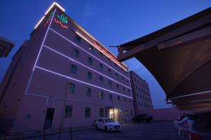 a building with a car parked in front of it at Palms Lily Hotel Suites in Al Ahsa