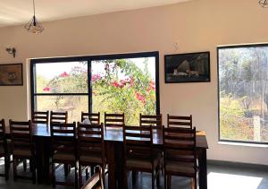 a dining room with a table and chairs and windows at Thour Nature Resorts Jawai in Bera