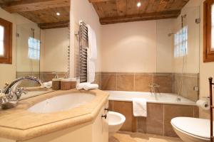a bathroom with a sink and a tub and a toilet at Chesa Cavril in Maloja