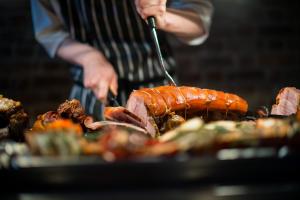 a man is preparing food on a grill at The Boathouse in Rollesby