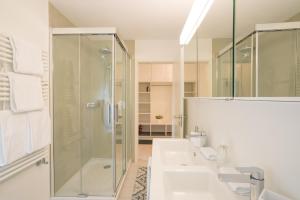 a bathroom with two sinks and a shower at Chesa Maria 7 in Sils Maria +16 photos