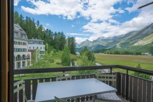 a balcony with a table and a view of mountains at Chesa Maria 7 in Sils Maria