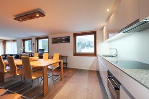 a kitchen and dining room with a wooden table and chairs at Chesa Soldanella 9 in Maloja