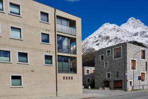 a building with a snow covered mountain in the background at Chesa Soldanella 9 in Maloja