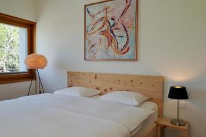 a bedroom with a bed and a painting on the wall at Chesa Soldanella 9 in Maloja
