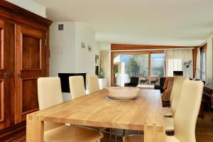 a dining room with a wooden table and chairs at Chesa Soldanella 9 in Maloja +18 photos