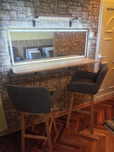 two chairs and a mirror in front of a brick wall at Apartman EN in Dušanovac (historical)