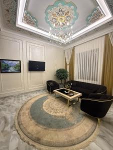 a living room with a couch and a chandelier at Hotel Bogatt in Dushanbe