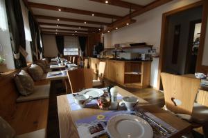a dining room with a long table and chairs at Garni Neidia in Selva di Val Gardena