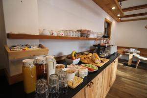 a kitchen with a counter with food on it at Garni Neidia in Selva di Val Gardena +10 photos
