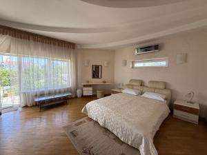 a bedroom with a large bed and a large window at Дом в Аркадии - море рядом! in Odesa