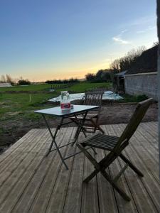 a table and two chairs on a wooden deck at Le Clos d'Hydrequent in Rinxent