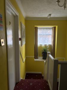 a small yellow room with a window and a staircase at Boscombe Spa Hotel in Bournemouth